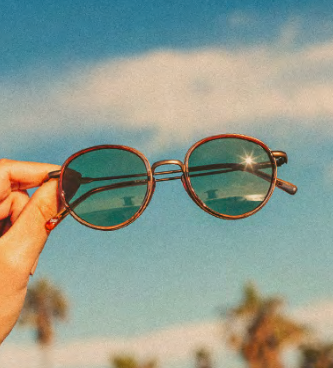 Baia sunglasses by Sunski held up against the sky