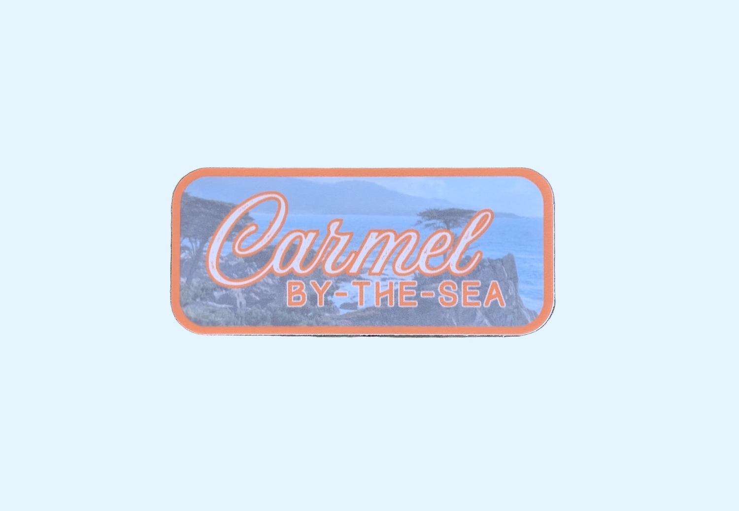 this orange bordered sticker represents Carmel By-the-Sea, featuring the famous Lone Cypress tree