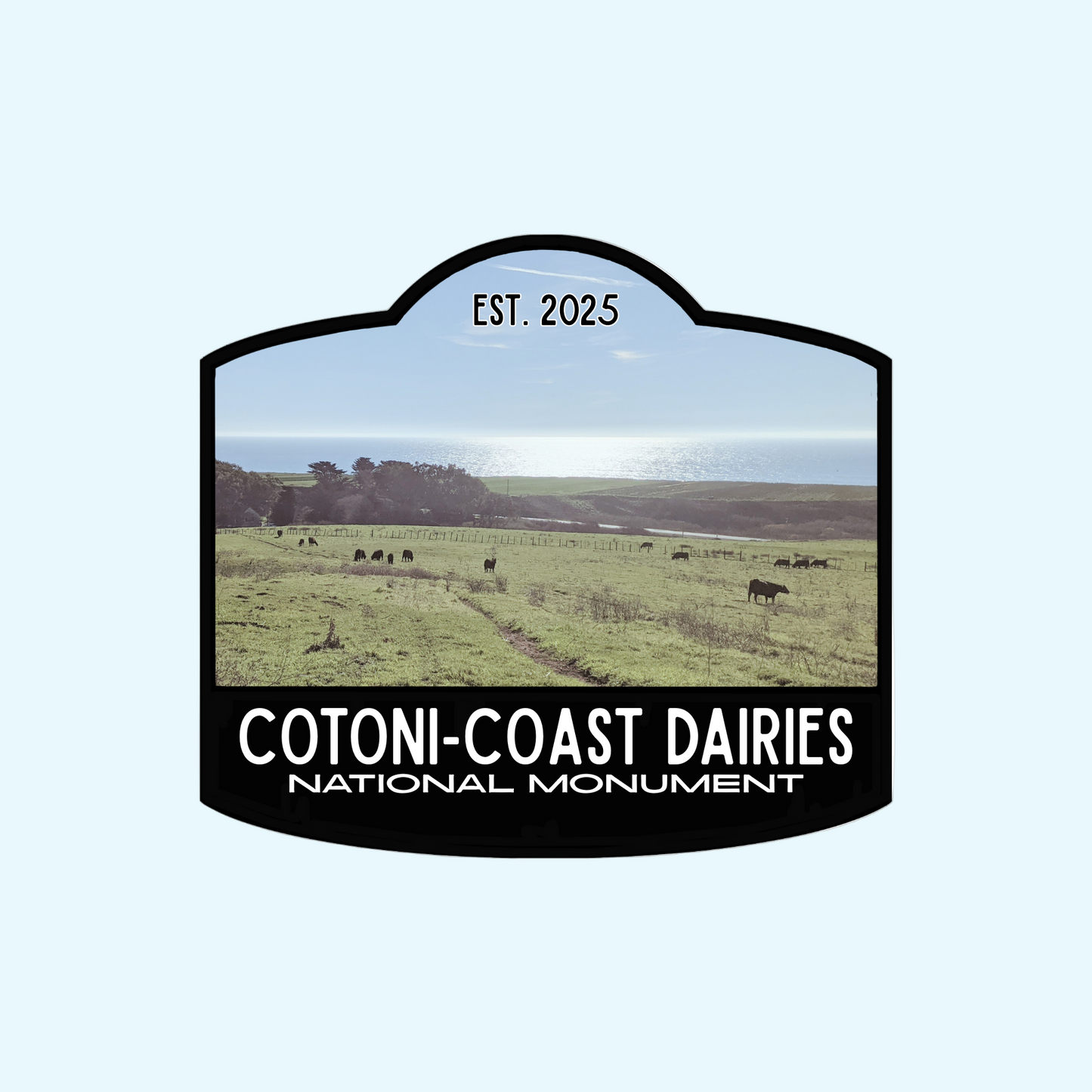 Black-bordered sticker  that reads Cotoni-Coast Dairies National Monument, Est 2025, with a photo of this new local gem north of Santa Cruz, California, USA in the background