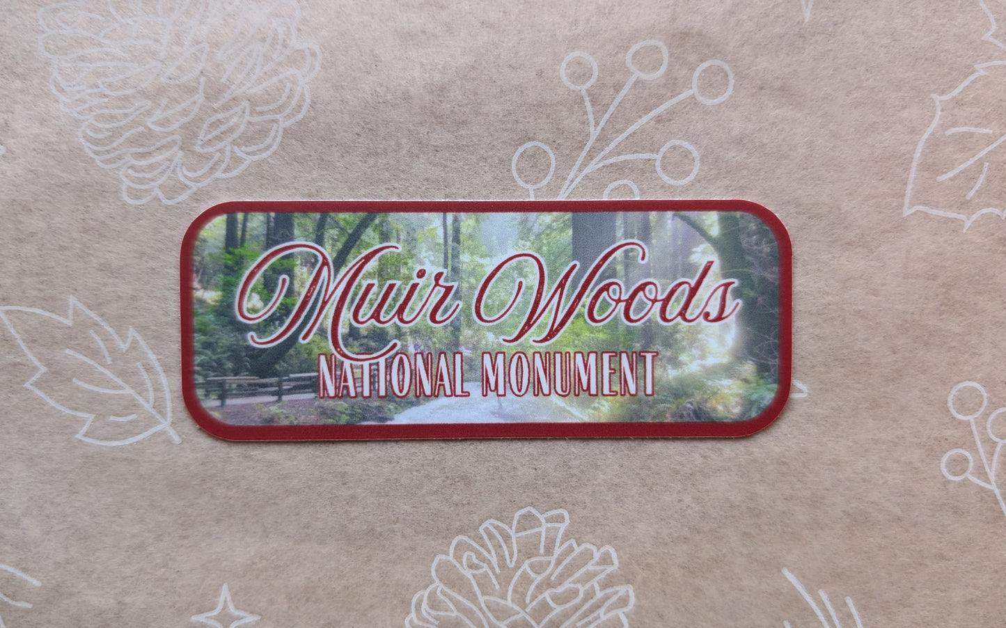 deep red bordered sticker represents Muir Woods National Monument with paper background