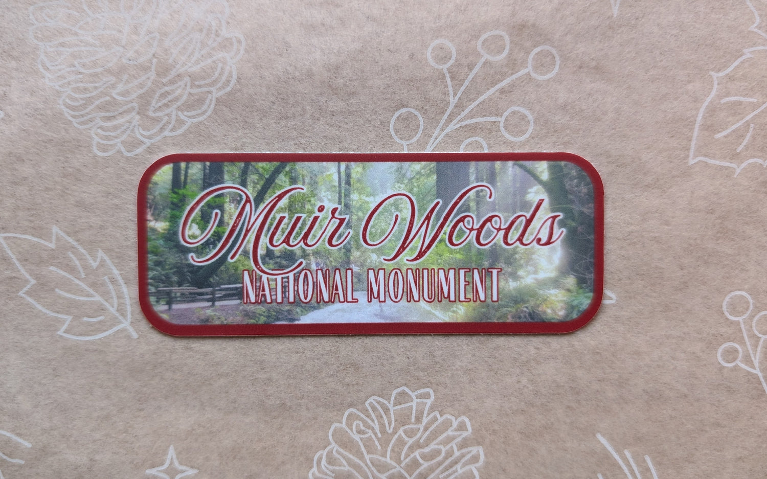 deep red bordered sticker represents Muir Woods National Monument with paper background
