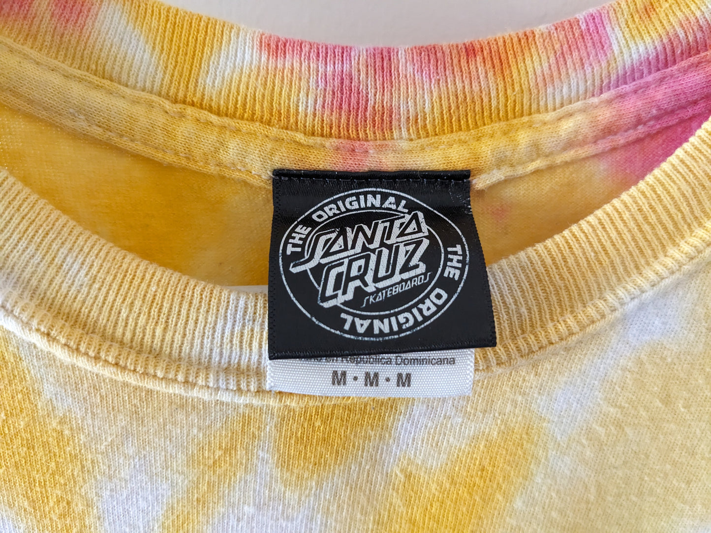 Rainbow tie dye shirt with Santa Cruz Screaming Hand in blue tag