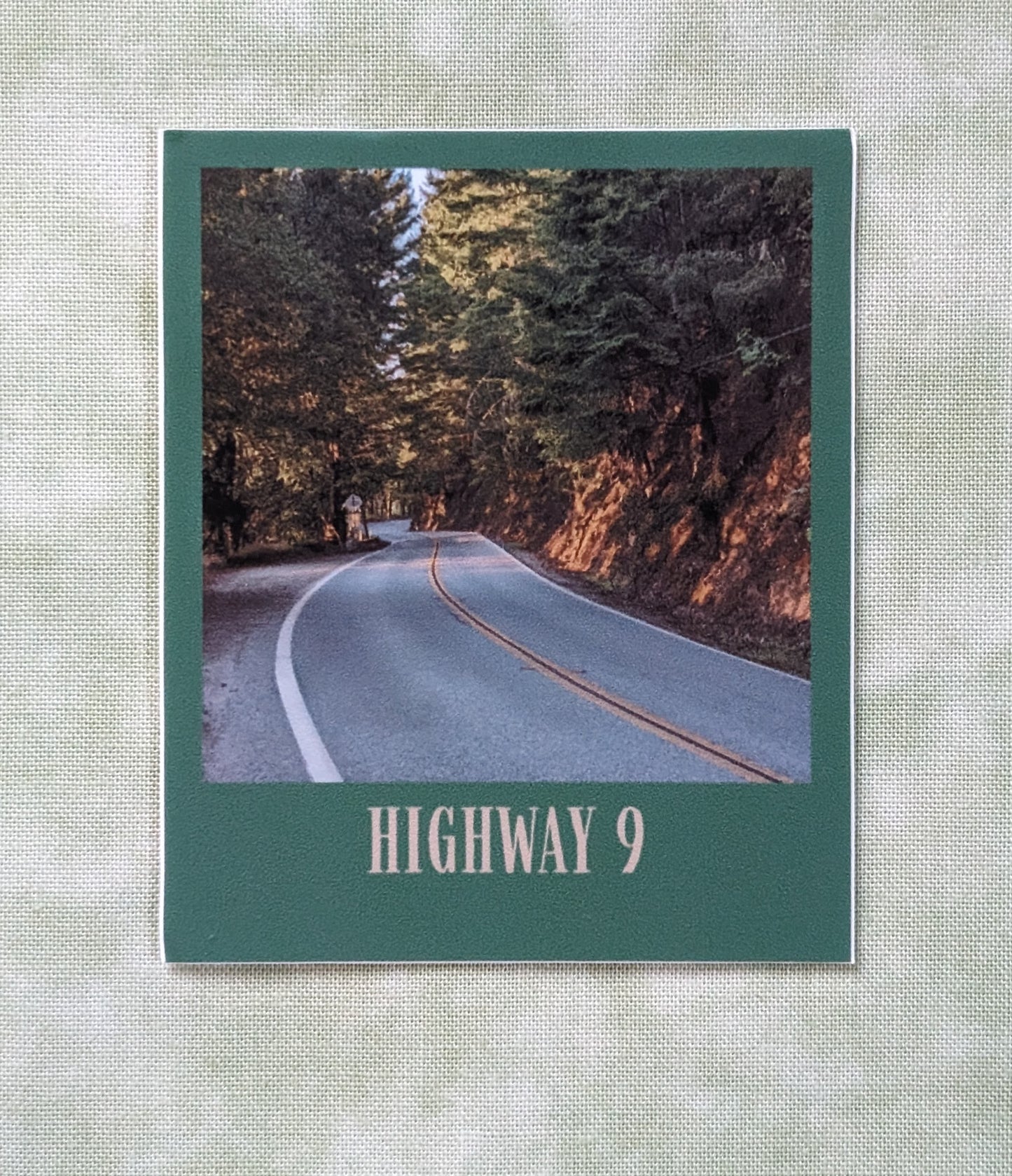 Forest green bordered sticker of photo of Highway 9
