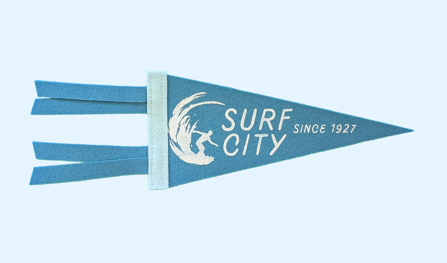Surf City, Since 1927 souvenir pennant representing Santa Cruz California with a surfer in a wave on blue felt