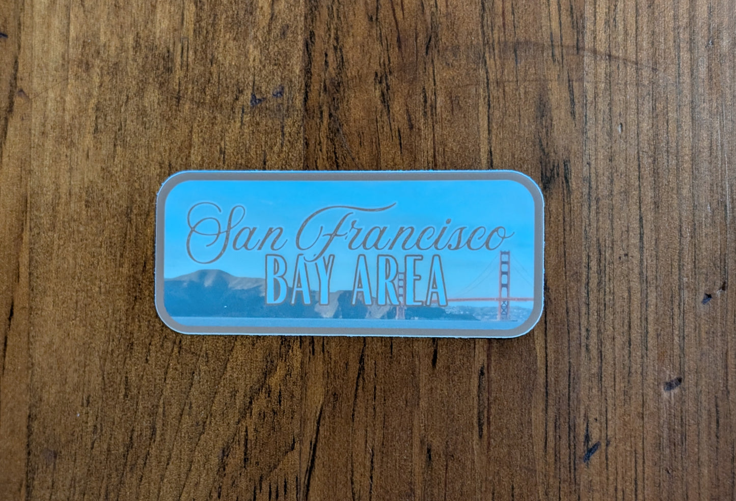 Brown bordered sticker represents the San Francisco Bay Area, featuring the Golden Gate Bridge in California with wood background