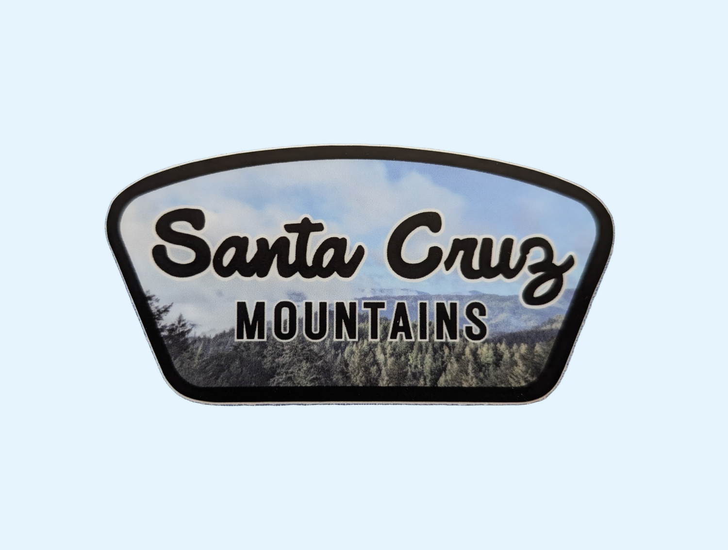 Santa Cruz Mountains badge sticker with black border and photo of foggy mountainside as background