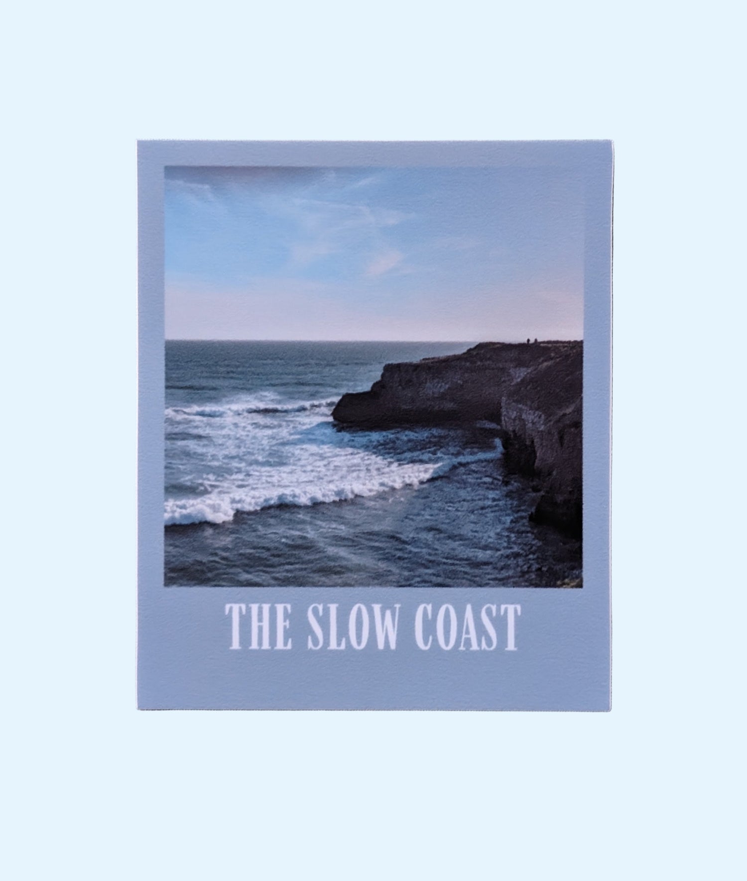 The Slow Coast sticker with a photo of coastal bluffs and a grayish blue border