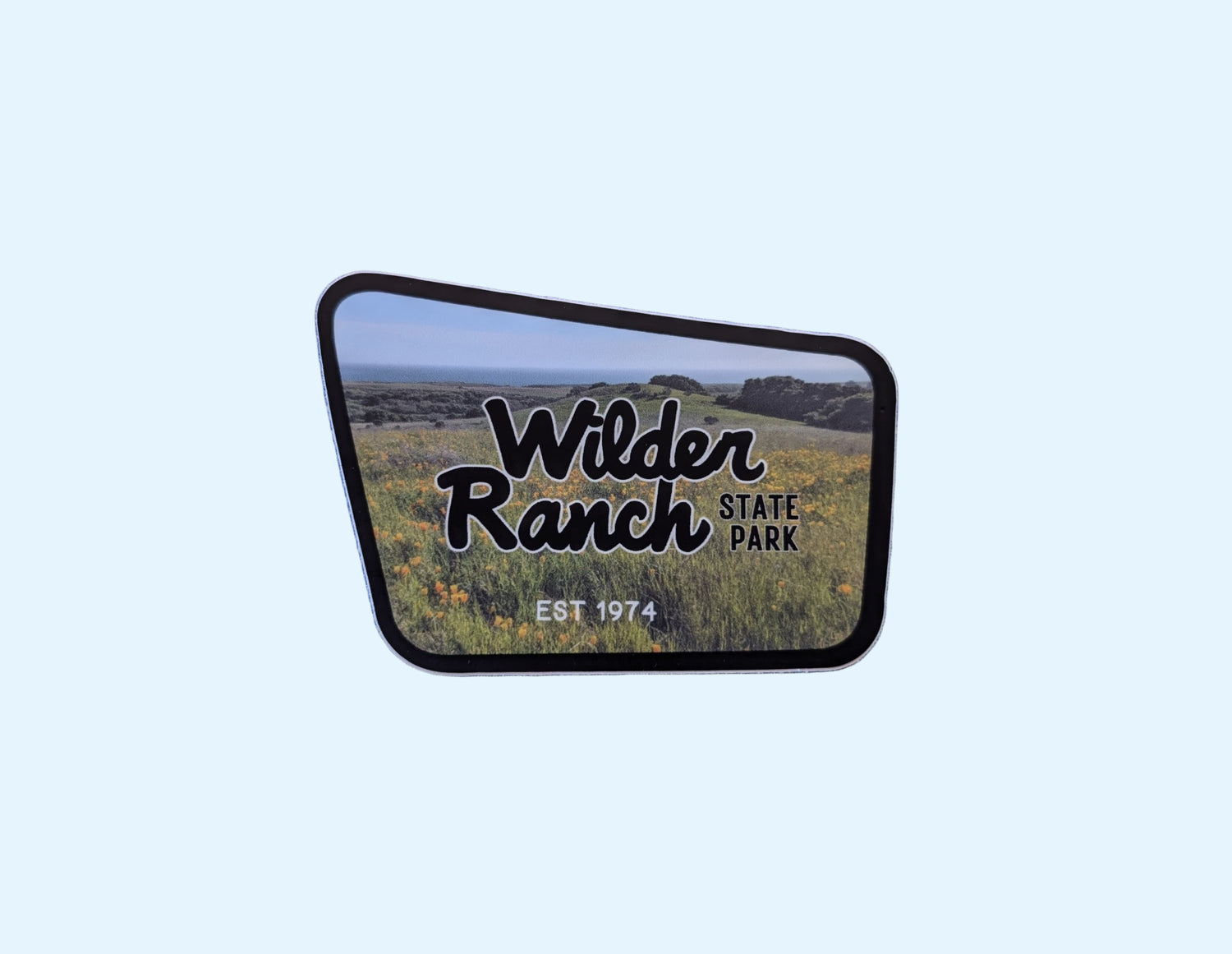 Wilder Ranch State Park sticker with black border and photo of the coastal bluffs in the background