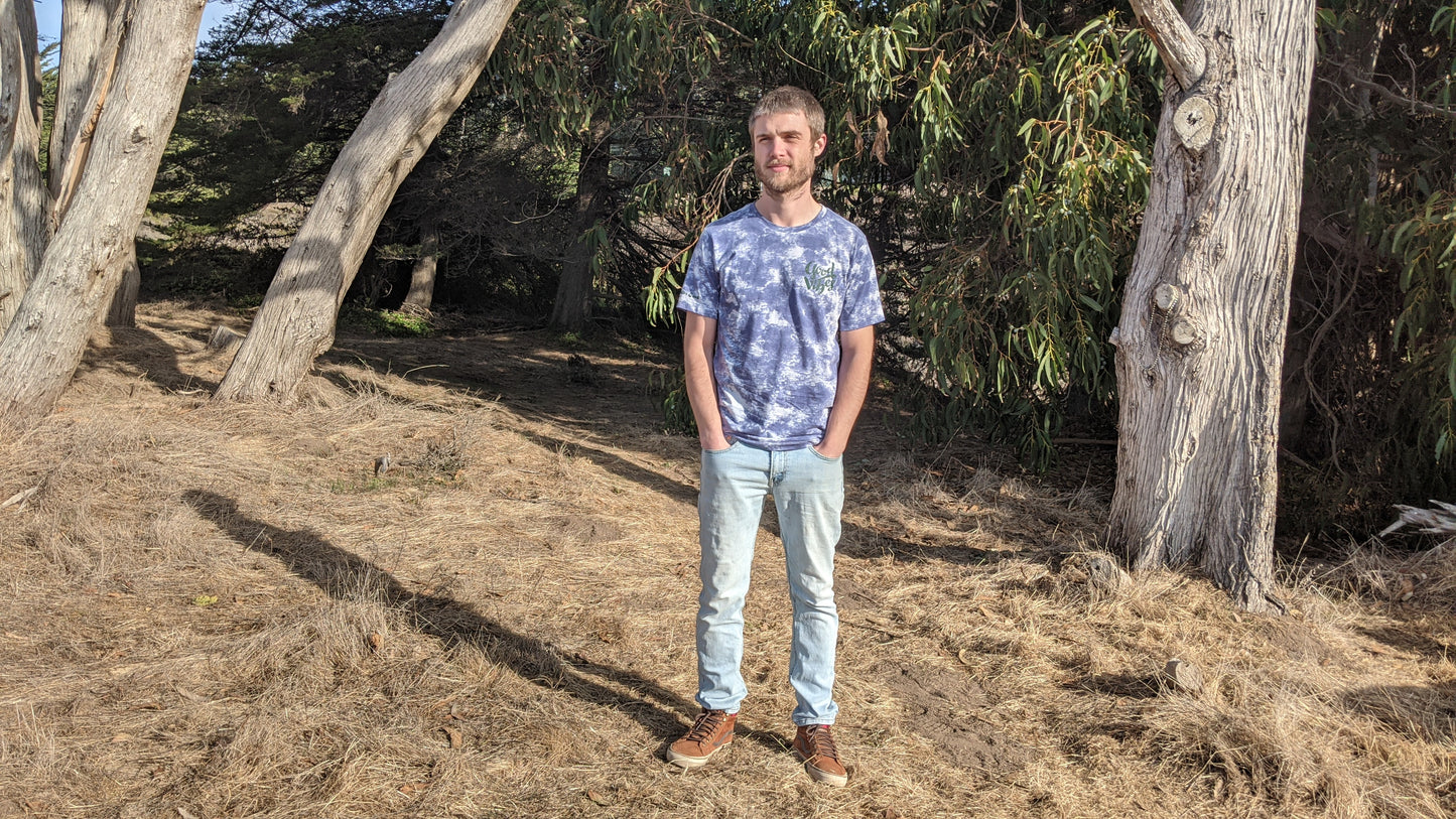 Model wearing blue and white tie dye Good Vibes shirt with jeans