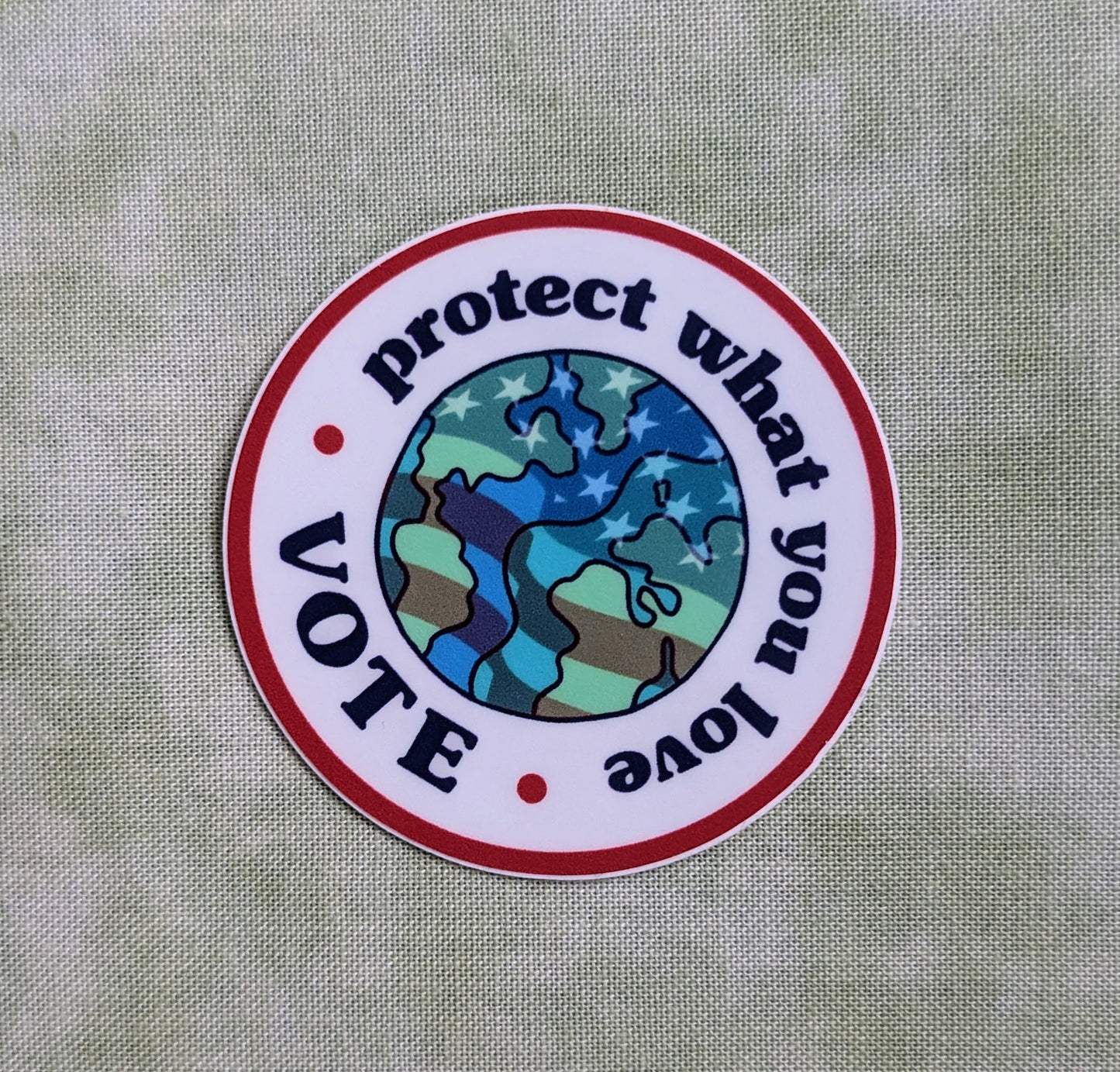 Round sticker reading Protect what you love, Vote with Earth and American flag in center