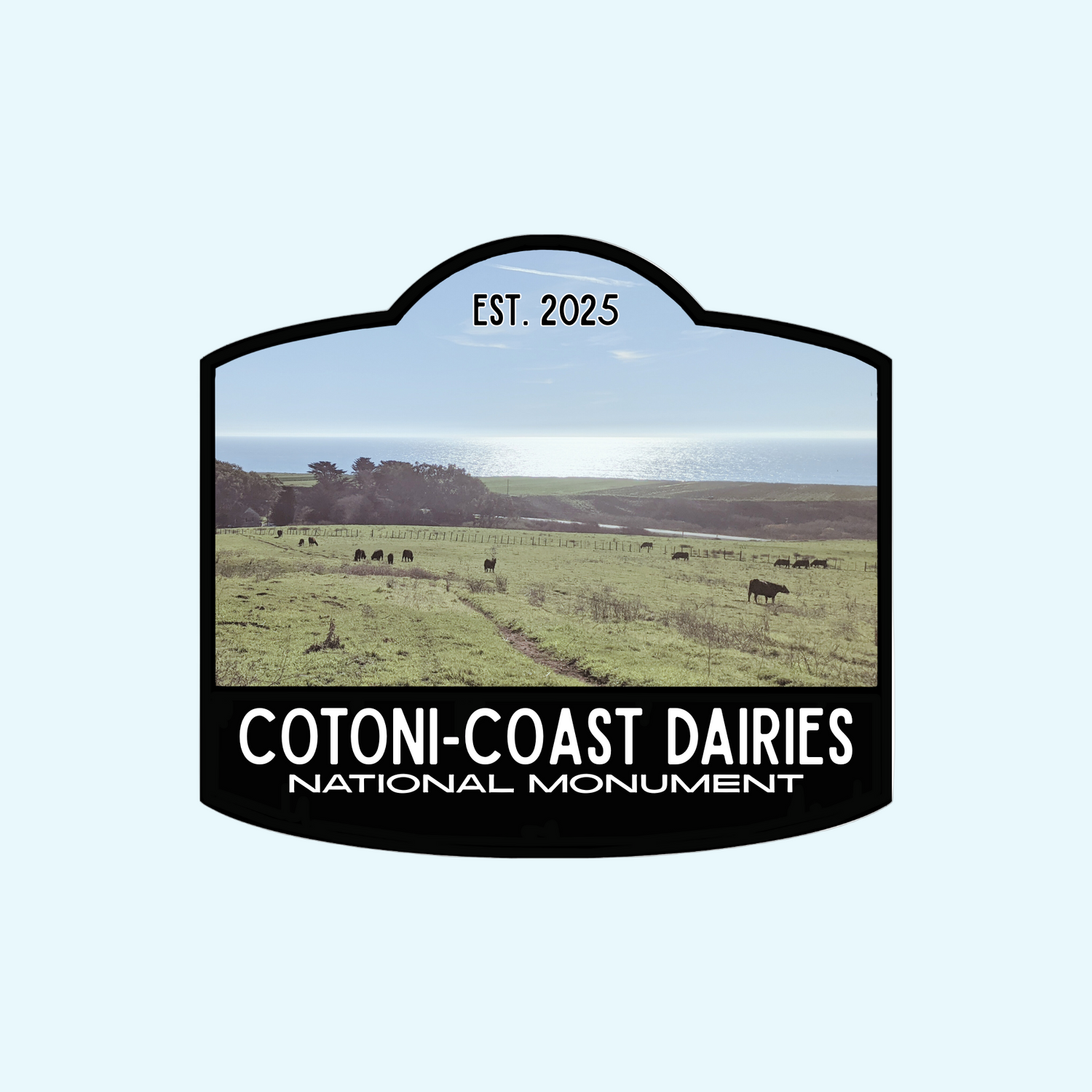 Black-bordered sticker  that reads Cotoni-Coast Dairies National Monument, Est 2025, with a photo of this new local gem north of Santa Cruz, California, USA in the background