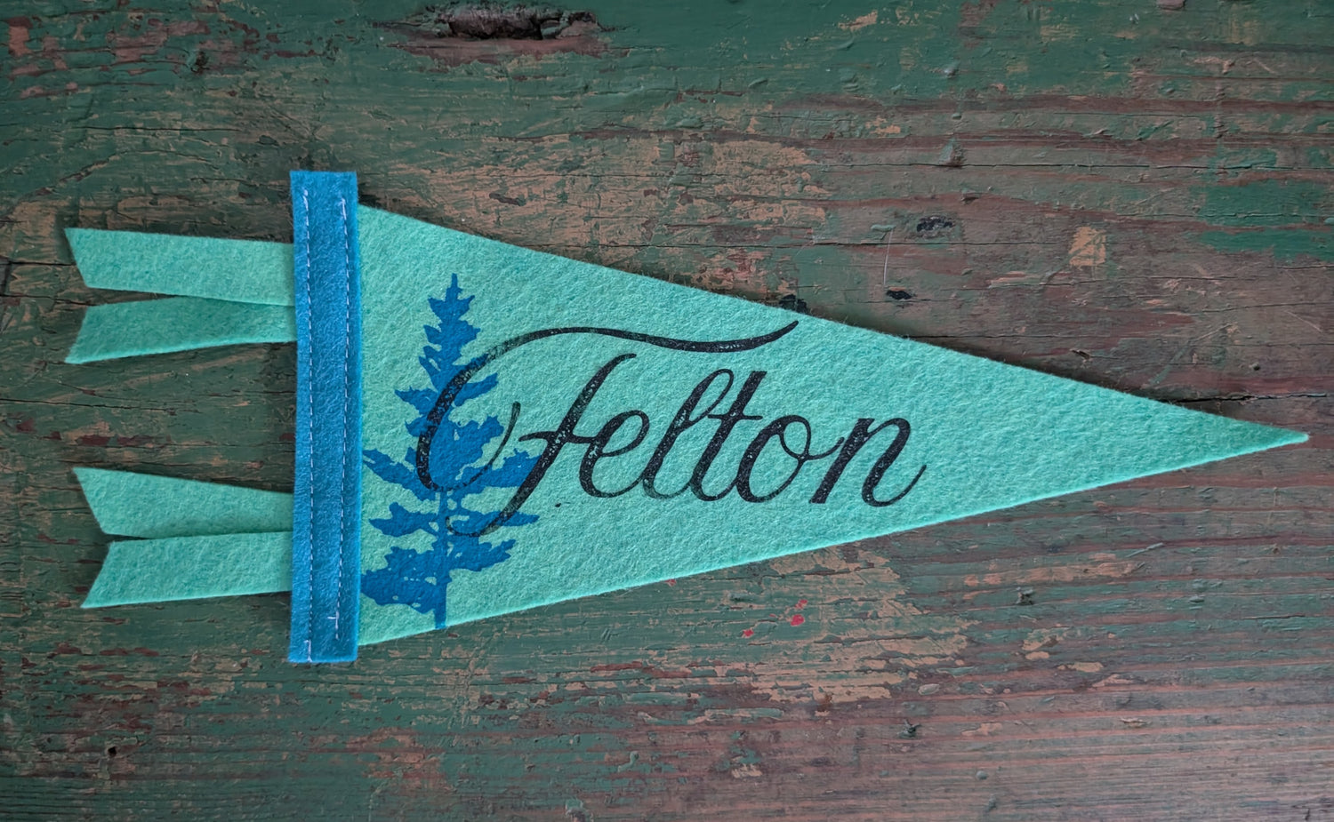 Mini clover pennant with the words "Felton" in black and a redwood in blue