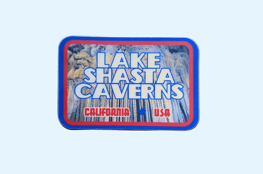 Blue and red-bordered rectangular sticker reads Lake Shasta Caverns, California, USA with a photo of this national landmark in Northern California in the background