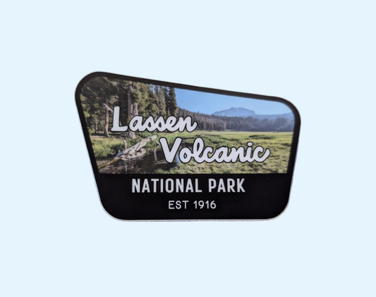 Lassen Volcanic National Park badge sticker with black border and photo of meadow and Lassen Peak volcano in the background