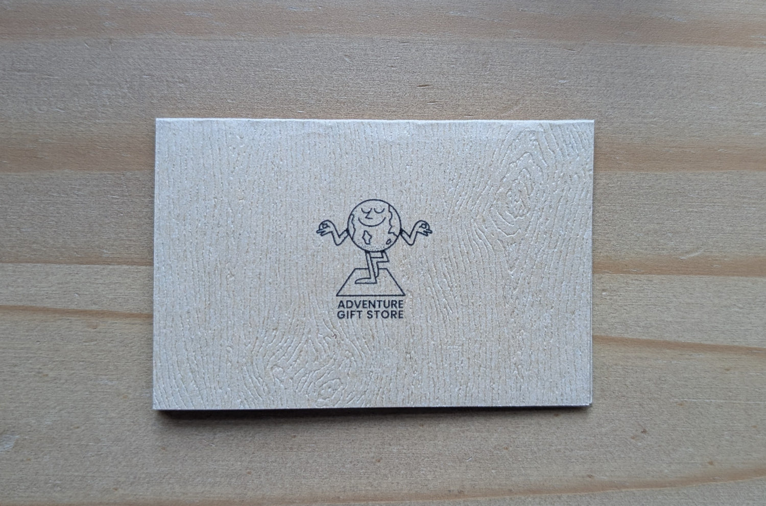 Mini card back with adventure gift store logo on wood grain brown paper
