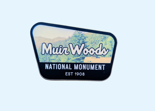 Black-bordered sticker that reads Muir Woods National Monument, Est 1908 with a photo of Muir Woods in Northern California, USA in the background