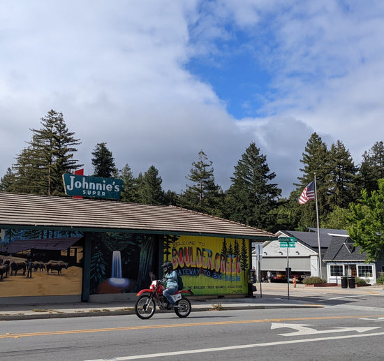 Cloudy day in downtown Boulder Creek, California with a motorcycle rider driving past Johnnie's Market