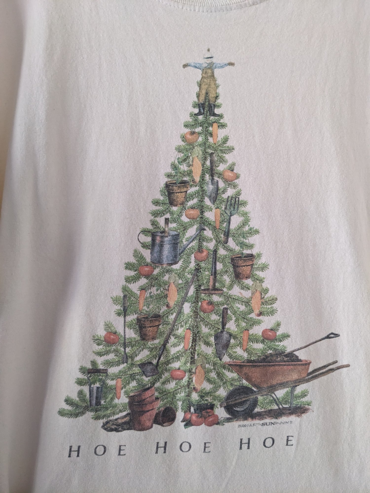 Off-white long sleeve shirt with Christmas tree with garden ornaments reading Hoe Hoe Hoe graphic close up