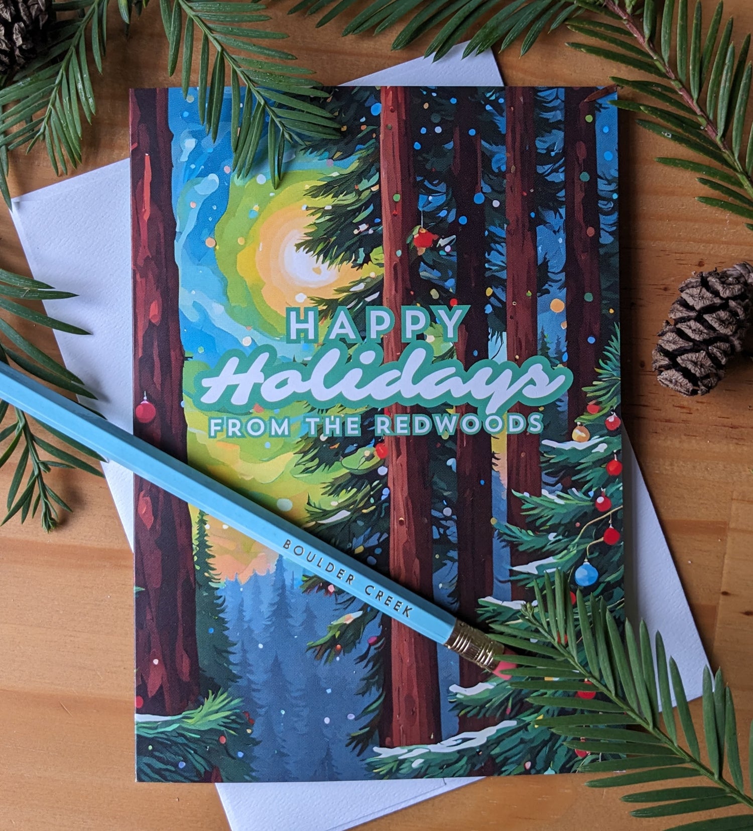 Happy Holidays from the Redwoods greeting card on table with redwoods about and a pencil reading Boulder Creek