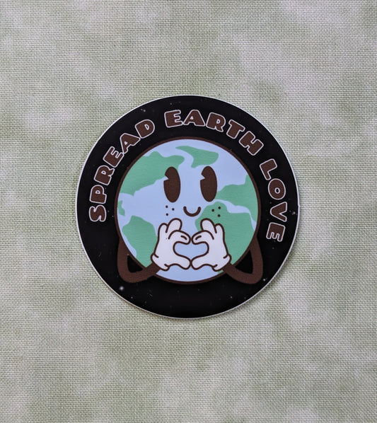 Black round sticker with earth making a heart with her hands and the words Spread Earth Love