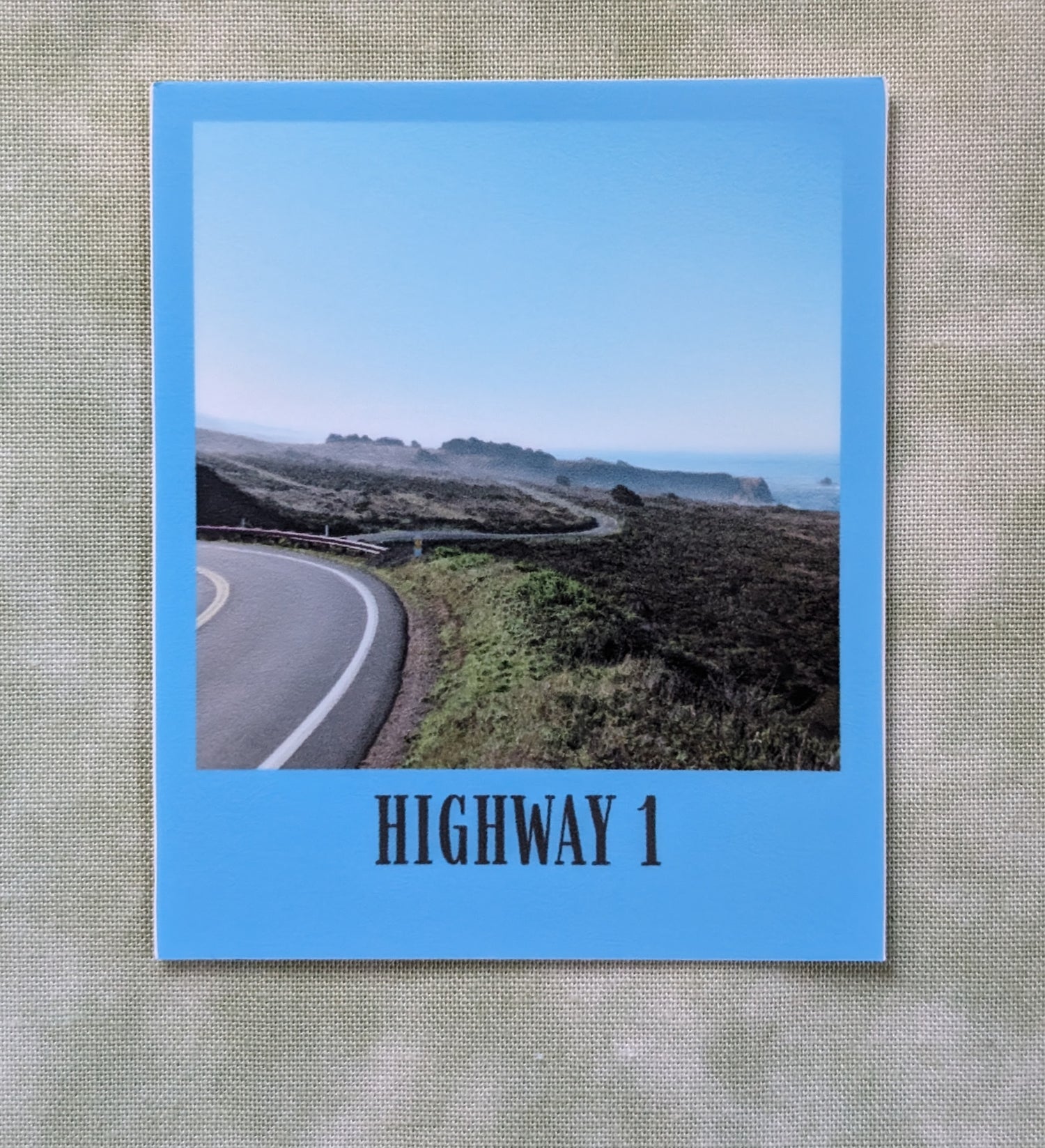Blue bordered sticker of photo of highway 1 in California