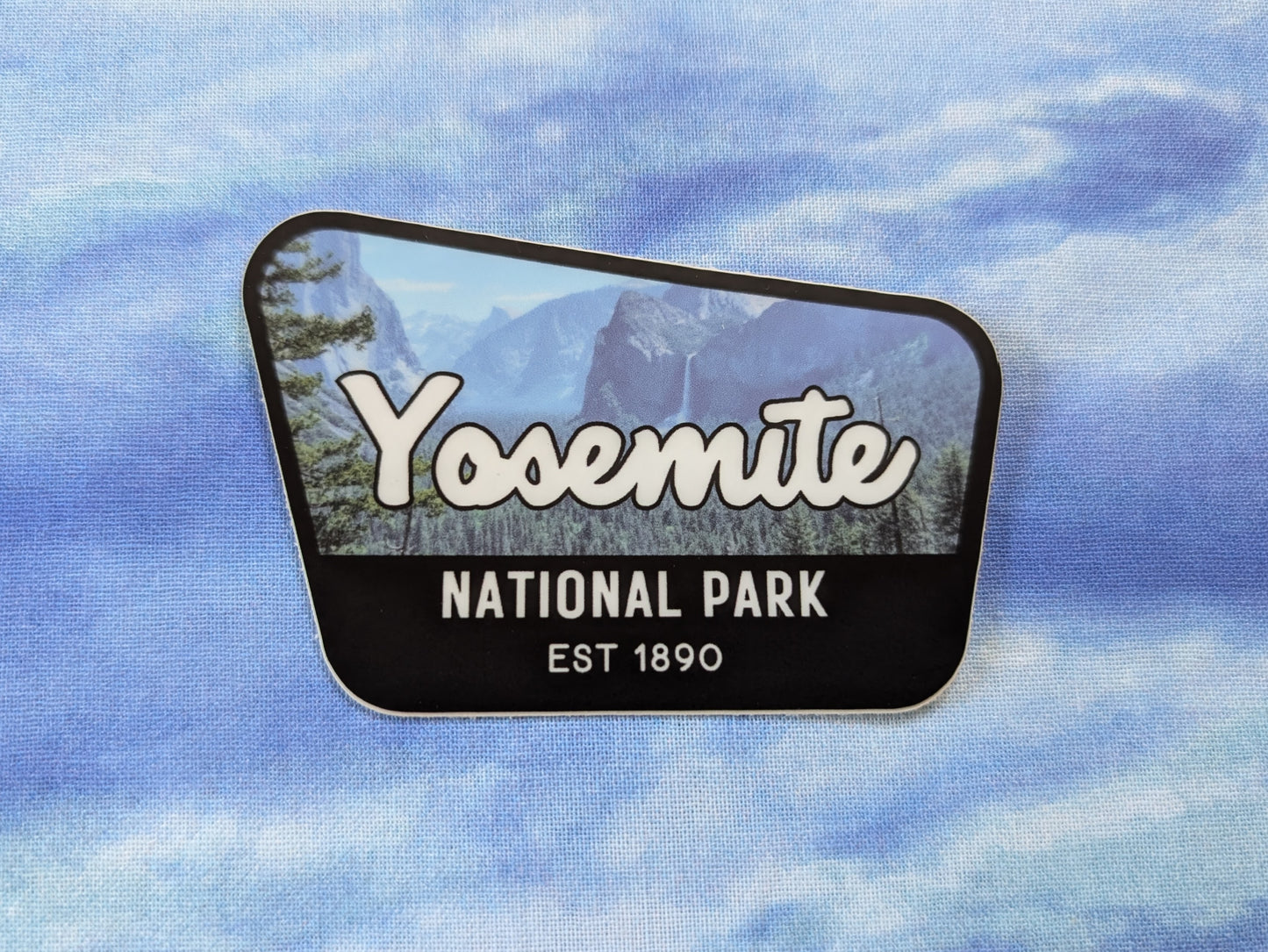 Yosemite National Park badge sticker with black border and photography of Yosemite Valley in the background