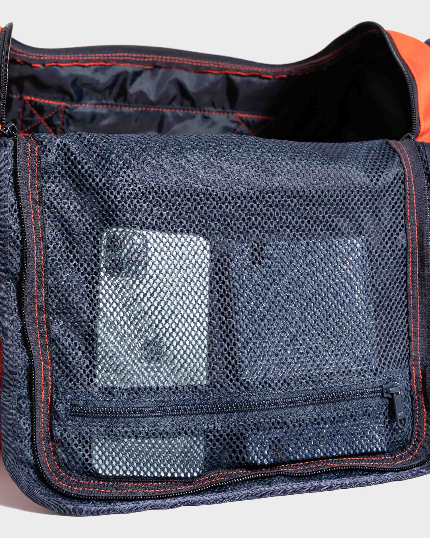 Inside top pocket of orange mini duffle bag by United by Blue