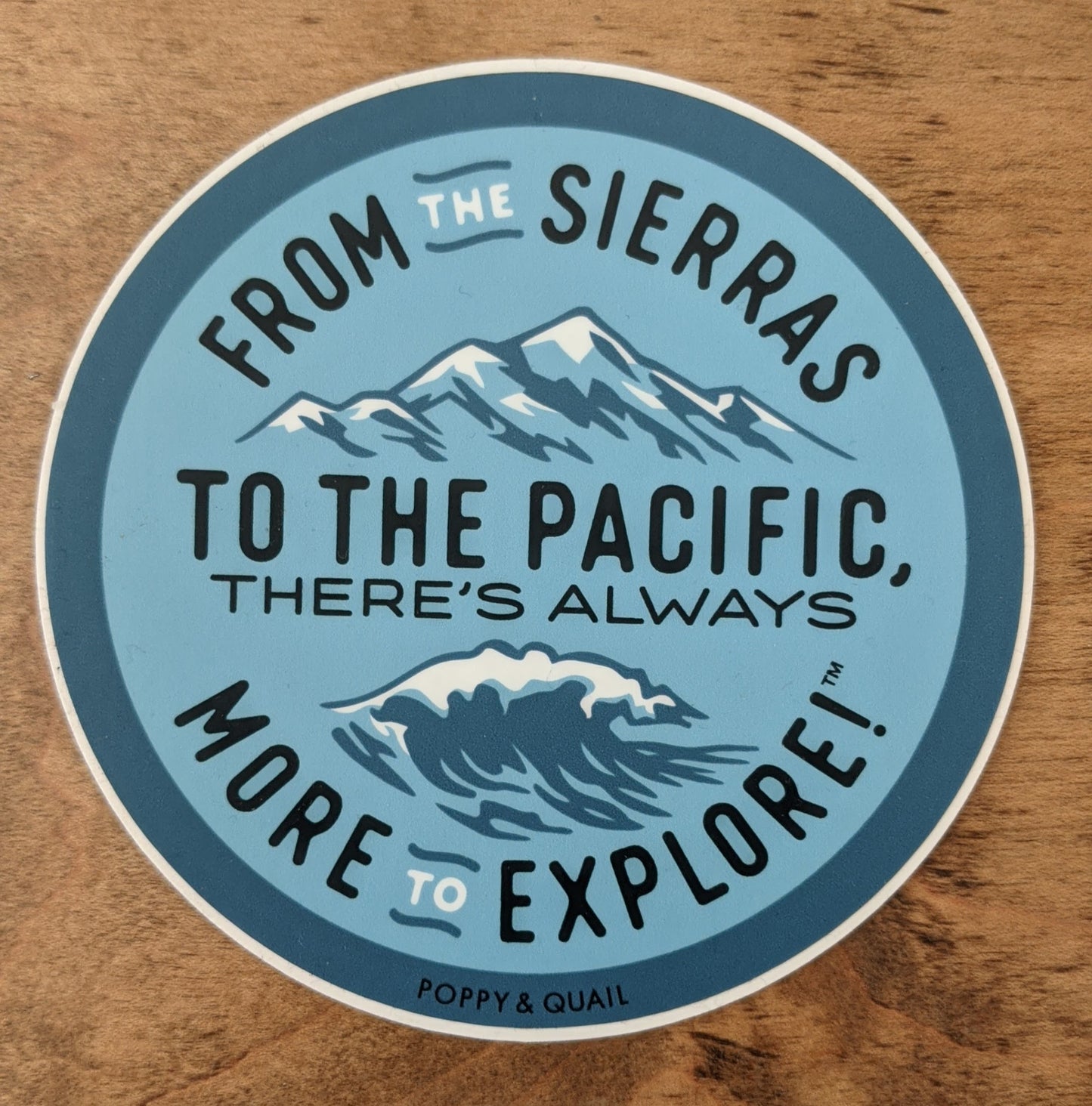 Large round blue sticker reading "From the Sierras to the Pacific, there's always more to explore" by Poppy & Quail