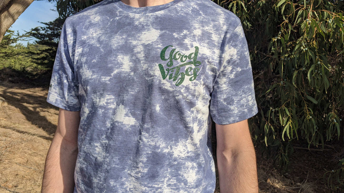 Blue and white tie dye shirt with Good Vibes in green ink on the front