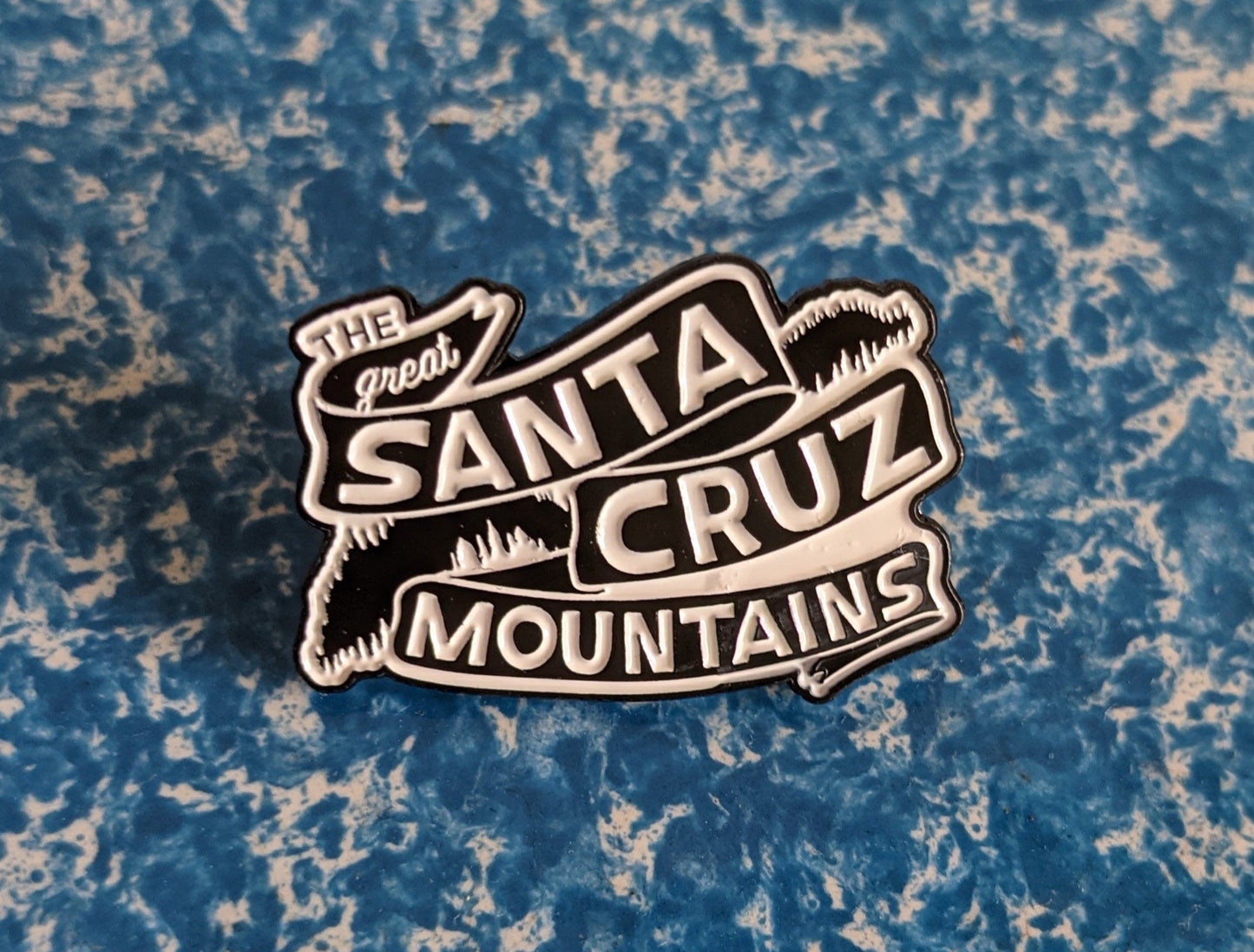 White and black soft enamel pin with Great Santa Cruz Mountains banner logo design