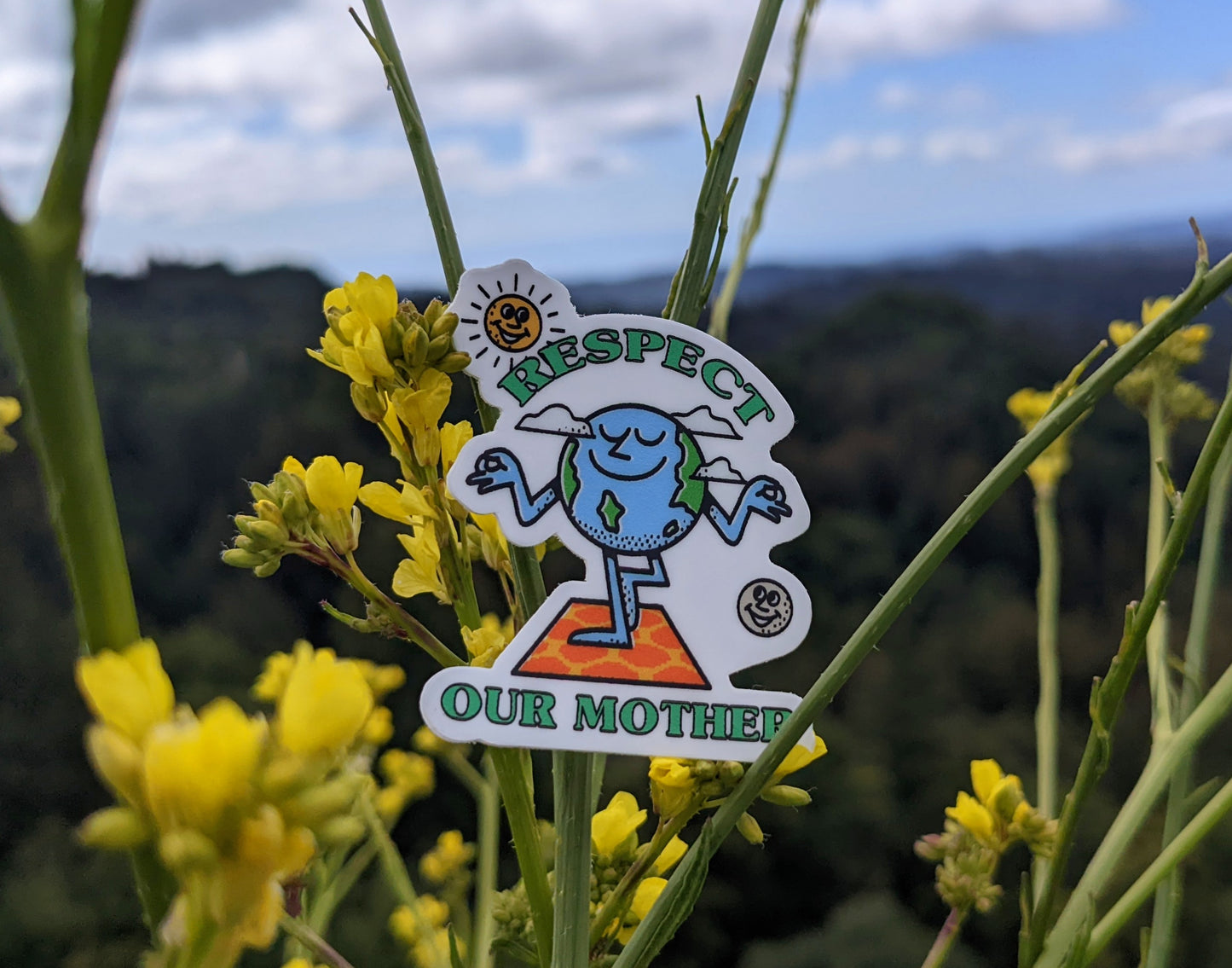 Respect our Mother sticker with Peaceful Earth, Sun and Moon with wildflowers and mountainscape in background