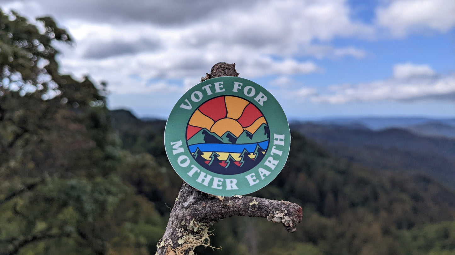 Vote for Mother Earth round sticker with Mountainscape sunset scene and mountain nature with sky in the background