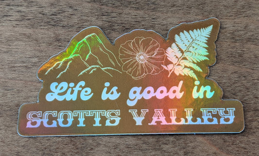 Mountain Talk holographic orange sticker reading  Life is good in Scotts Valley