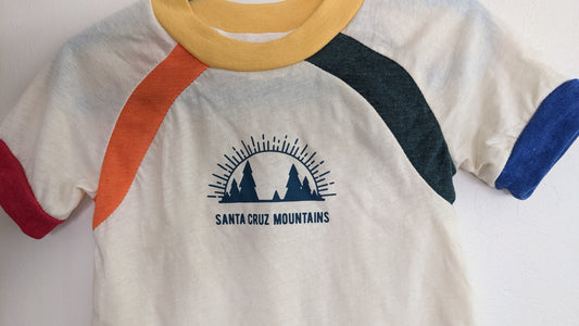 White kids shirt by Camp Collection with rainbow accents and Santa Cruz Mountains Present logo mark design on front,  created by Jackie from Present