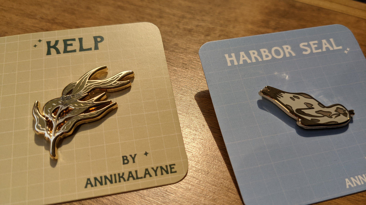 Harbor Seal and Kelp enamel pins by Annika Layne