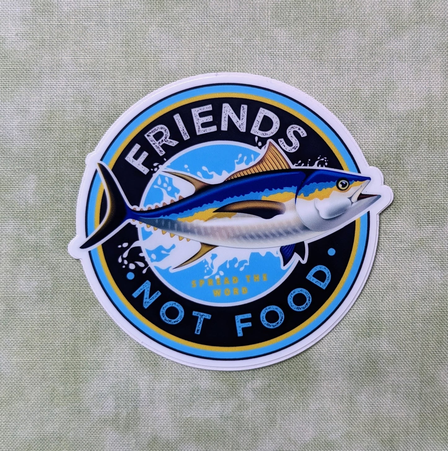 Round sticker reading "Friends, not food" with tuna fish,  created by Jackie from Present
