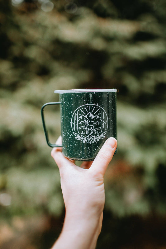 Green metal camping mug with lid and forest mountain scene by Miir and Good + Well Supply Co