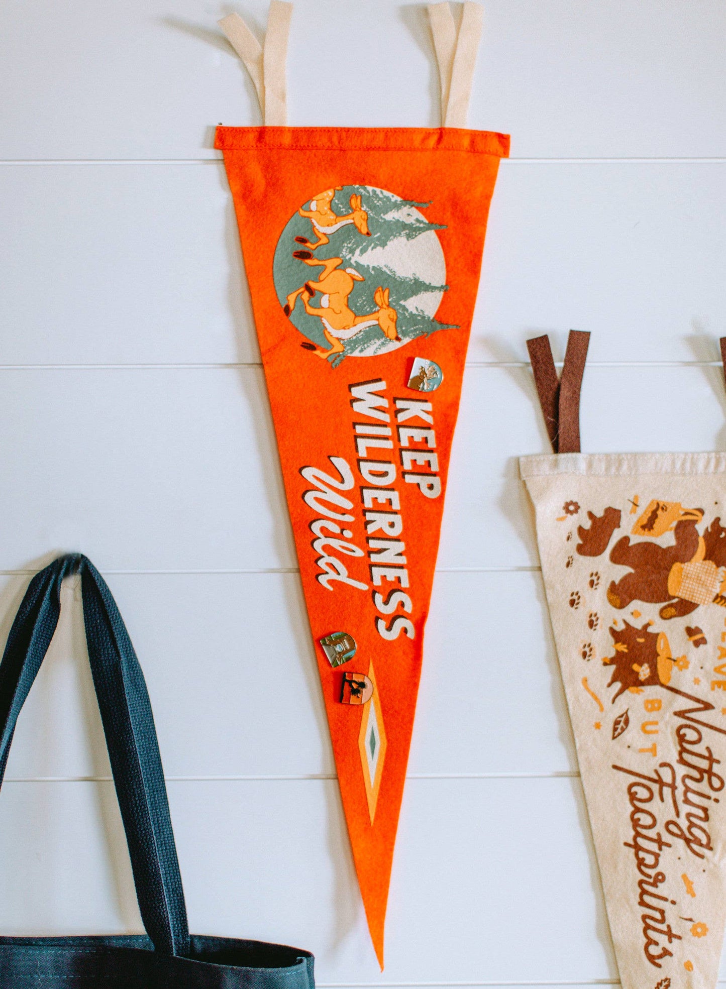 Bright orange pennant with deer in a forest, reading "Keep Wilderness Wild" by Oxford Pennant and Good + Well Supply Co